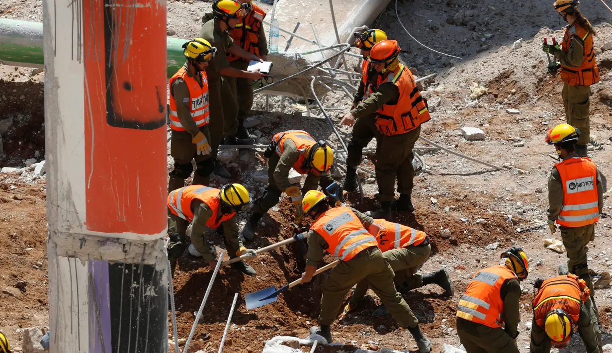 Petugas penyelamat mencari korban dengan menggali reruntuhan ambruknya gedung parkir yang sedang dibangun di Tel Aviv, Israel, Senin (5/9). Sebanyak 15 orang terjebak dalam reruntuhan tersebut. (REUTERS/Nir Elias)
