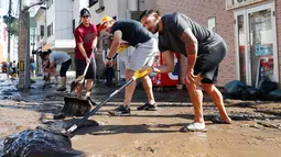 Para pemain rugby Kanada secara sukarela membersihkan jalan usai terjadi Topan Hagibis di Kamaishi, Prefektur Iwate, Jepang, Minggu (13/10/2019). Topan Hagibis membuat pertandingan Rugby World Cup Pool B antara Kanada dengan Namibia dibatalkan. (Kyodo News via AP)