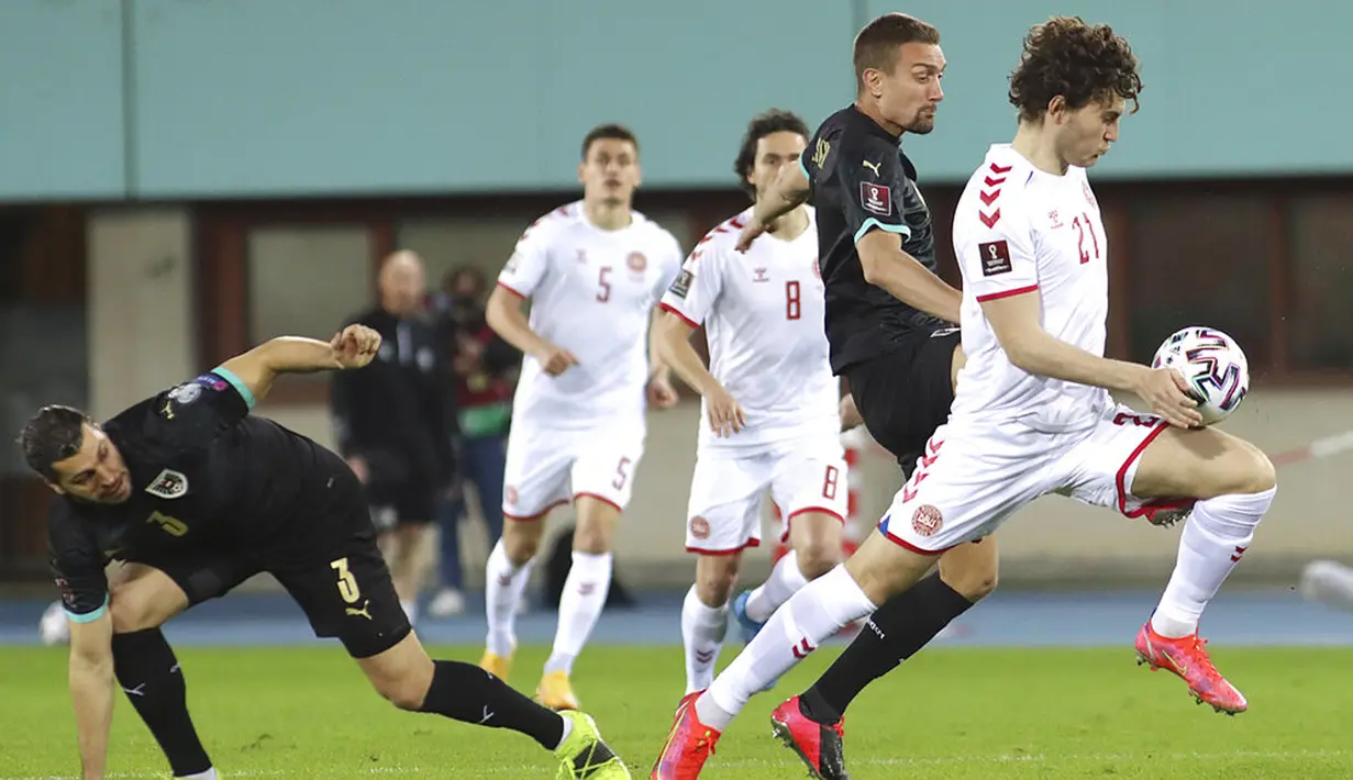 Pemain Denmark Jonas Wind (kanan) memperebutkan bola dengan pemain Austria Stefan Ilsanker pada pertandingan Grup F kualifikasi Piala Dunia 2022 di Ernst-Happel-Stadium, Wina, Austria, Rabu (31/3/2021). Denmark membantai Austria 4-0. (AP Photo/Ronald Zak)