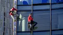 Alain Robert yang dikenal sebagai 'Spiderman Prancis' (kiri) dan Leo Urban memanjat gedung pencakar langit Skyper di pusat Frankfurt, Jerman, 23 November 2021. Alain 
 Robert telah memanjat lebih dari 100 bangunan dalam 30 tahun karirnya dan ditangkap puluhan kali. (AP Photo/Michael Probst)