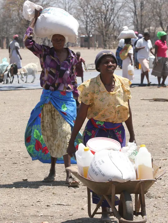 Warga mengambil bantuan makanan dari World Food Programme di Chiredzi Mupinga, Zimbabwe, Selasa (6/10). Puluhan juta orang di seluruh wilayah sub-Sahara Afrika akan mengalami kelaparan akibat siklus El Nino mencapai puncaknya. (REUTERS/Philimon Bulawayo)