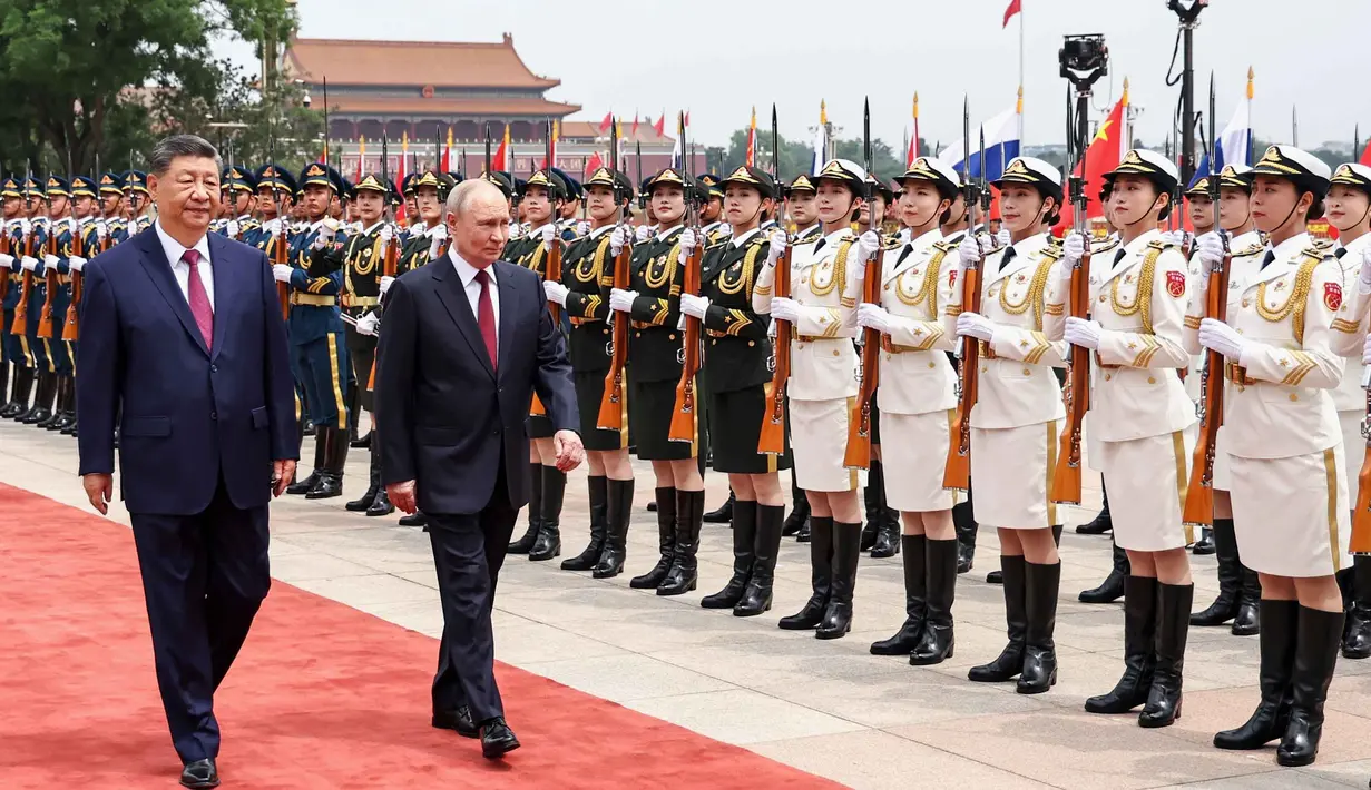 Presiden Rusia Vladimir Putin (kanan) dan Presiden China Xi Jinping memeriksa barisan kehormatan selama upacara penyambutan di Balai Besar Rakyat, Beijing, China, pada Rabu 20 Mei 2026. (Alexander Kazakov, Sputnik, Kremlin Pool Photo via AP)