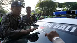 Polisi menempelkan stiker bendera Indonesia dan Arab Saudi selama persiapan menyambut kedatangan Raja Arab Saudi Salman bin Abdulaziz di Nusa Dua, Bali (2/3). Raja Salman akan berlibur di Bali tanggal 4 sampai 9 Maret. (AFP Photo / Sonny Tumbelaka)