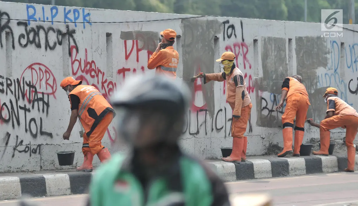Petugas PPSU membersihkan coretan yang mengotori tembok di kawasan Gedung DPR, Jakarta, Rabu (25/9/2019). Demonstrasi mahasiswa yang berujung ricuh yang berujung kerusuhan tersebut menyebabkan fasilitas umum rusak dan penuh coretan yang dibuat oleh pendemo. (merdeka.com/Iqbal S Nugroho)