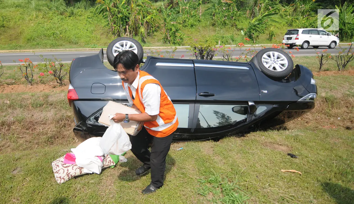 Petugas menunjukkan SIM A milik sopir mobil Innova yang terbalik di KM 208 Tol Palikanci (Palimanan-Kanci), Jawa Barat, Rabu (21/6). Sopir mobil itu diduga mengantuk dan membanting setir hingga mengakibatkan mobil terbalik. (Liputan6.com/Gempur M Surya)