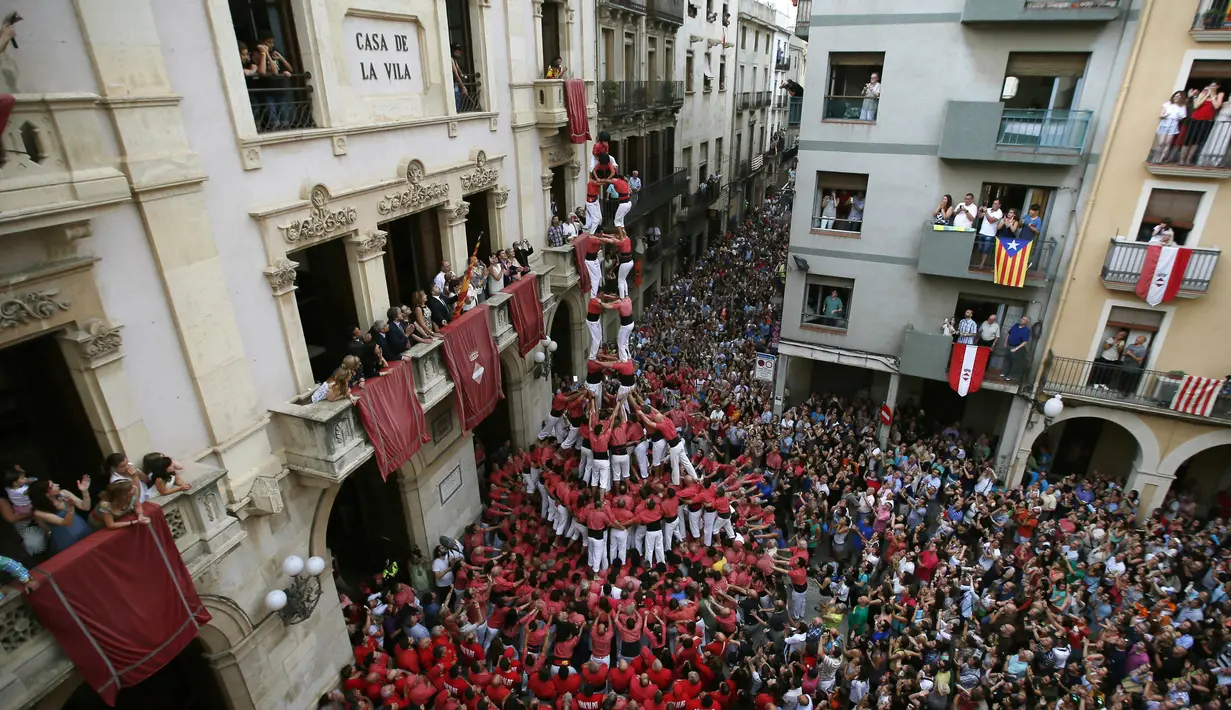 Kompetisi membangun menara manusia oleh ratusan orang dalam festival Sant Joan dikenal dengan istilah "castells", Spanyol, Selasa (24/6/14). (REUTERS/Albert Gea)