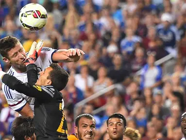 Pemain Chelsea Gary Cahill duel udara dengan kiper Barcelona Jordi Masip saat mencetak gol pada Laga International Champions Cup di FedEx Field, AS, Rabu (29/7/2015) pagi WIB. (AFP Photo/Nicholas Kamm)