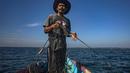 Erwin, seorang nelayan, menggunakan jaring untuk menangkap ikan di perairan Tanah Kuning, dekat lokasi pengembangan Kalimantan Industrial Park Indonesia, di Kalimantan Utara, Indonesia pada hari Kamis, 24 Agustus 2023. (AP Photo/Yusuf Wahil)