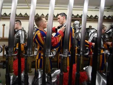 Pasukan Pengawal Swiss berdandan sebelum menghadiri upacara tahunan di Kota Vatikan (6/5). Swiss Guard adalah pasukan yang berasal dari Swiss namun mengabdikan diri kepada negara lain. (AFP/Filippo Monteforte)