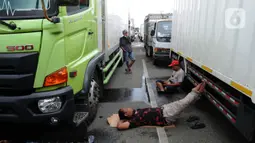  
Kernet truk beristirahat saat antrian truk menuju  Pelabuhan Gilimanuk, Jembrana, Bali, Sabtu (304/2022). Pelabuhan Gilimanuk Bali dipadati oleh ribuan kendaraan pemudik yang akan menyeberang ke Pulau Jawa pada H-2 Hari Raya Idul Fitri 1443 H. (merdeka.com/Arie Basuki)