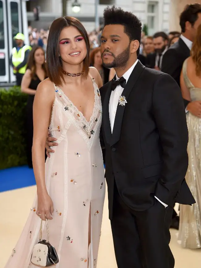 The Weeknd yang hadir dengan setelah jasnya berwarna hitam membuatnya begitu gagah dan tampan. Sedangkan Selena yang memakai gaun berwarna putih yang bermotif sederhana, dipadu tatana rambut yang dibiarkan terurai. (AFP/Bintang.com)