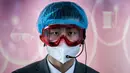 Pekerja mengenakan alat pelindung sebagai tindakan pencegahan terhadap COVID-19 di area kedatangan yang hampir kosong di Bandara Ibu Kota Beijing, 16 Maret 2020. Masker dijadikan masyarakat pilihan untuk mencegah penyebaran virus corona yang terus meningkat di seluruh dunia.  (NICOLAS ASFOURI/AFP)
