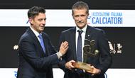 Wasit Italia, Daniele Orsato, berpose di atas panggung setelah menerima penghargaan 'Wasit Terbaik' dari Gianluca Rocchi (kiri) selama acara penghargaan Italian Footballers' Association (AIC) 2023 pada 4 Desember 2023 di Milan. (Marco BERTORELLO/AFP)