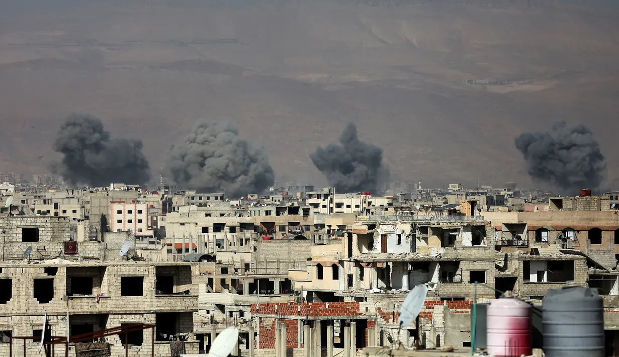 Kondisi kota Arbin yang dipenuhi kepulan asap usai terkena serangan udara dari pasukan Assad di wilayah Ghouta Timur, Suriah (7/2). Akibat serangan ini dilaporkan sedikitnya, 47 warga sipil tewas. (AFP Photo/Amer Almohibany)