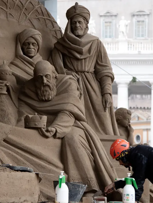 Seniman Rusia Ilya Filimontsev saat membuat patung pasir adegan kelahiran Yesus di St Peter, Vatikan, Kamis (6/12). Untuk membuat patung pasir adegan kelahiran Yesus yang menghabiskan pasir 720 ton. (Tiziana FABI/AFP)
