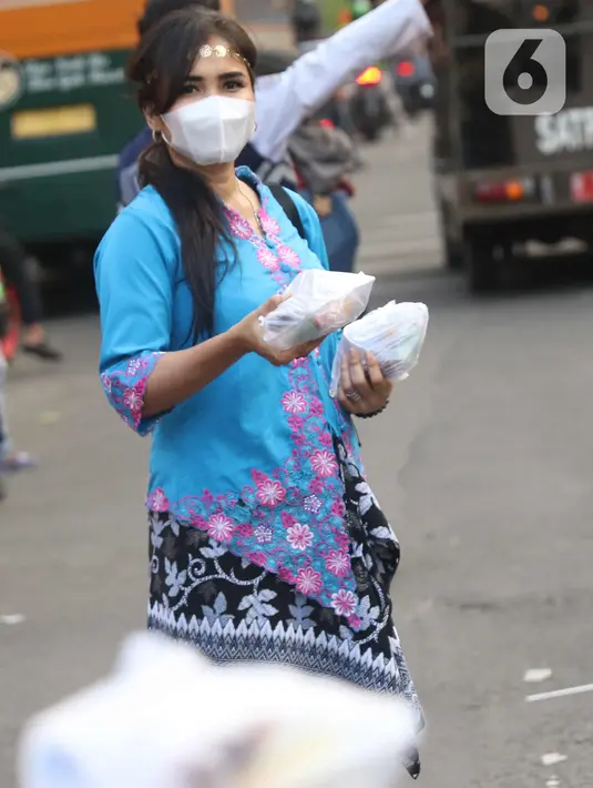 Sejumlah perempuan dengan mengenakan kebaya membagikan takjil untuk berbuka puasa bagi pengendara yang melintas di kawasan Tangerang, Banten, Rabu (21/4/2021). Pembagian takjil dengan mengenakan kebaya tersebut untuk merayakan Hari Kartini. (Liputan6.com/Angga Yuniar)