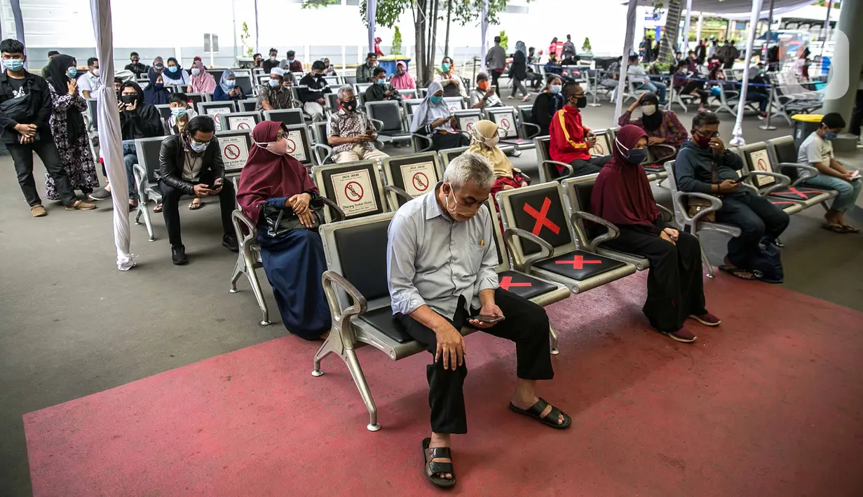 Calon penumpang mengantre untuk menjalani swab antigen di Stasiun Senen, Jakarta, Senin (21/12/2020). Penumpang kereta api jarak jauh menunjukkan surat bebas Covid-19 dengan melakukan tes PCR atau tes rapid antibodi yang masih berlaku 14 hari sejak diterbitkan. (Liputan6.com/Faizal Fanani)