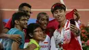  Pelari Indonesia, Agus Prayogo (kedua kanan) berfoto bersama penggemarnya usai merayakan kemenangannya di nomor lari 10.000 m putra SEA Games 2015 di National Stadium, Singapura, Rabu (10/6/2015). (Liputan6.com/Helmi Fithriansyah)