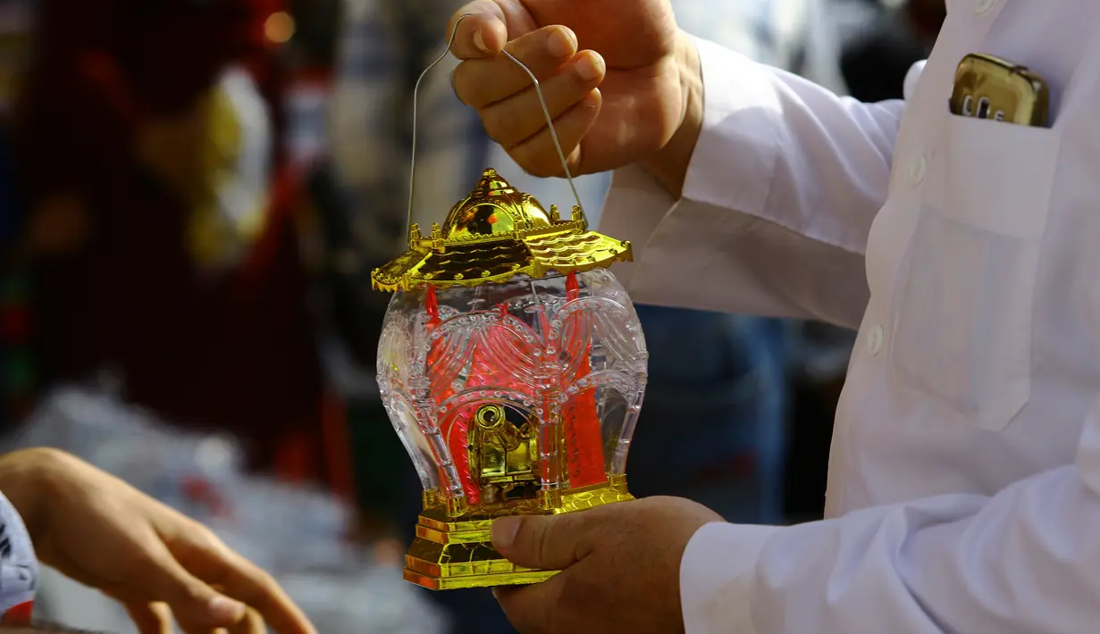 Seorang pria memeriksa lentera Ramadan yang akan dibelinya di salah satu kios di pasar Kota Gaza, Kamis (25/5). Warga Palestina merayakan datangnya bulan puasa dengan memasang lentera tradisional khas Ramadan sebagai dekorasi rumah. (AP Photo/Adel Hana)