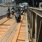 Pengendara motor melintas di jembatan darurat atau bailey Cikereteg di Jalan Raya Bogor-Sukabumi, Bogor, Jawa Barat, Senin (13/3/2023). Mulai Senin, (13/3/2023) jalur tersebut kembali dibuka hanya untuk kendaraan kecil dengan sistem buka tutup. (merdeka.com/Arie Basuki)