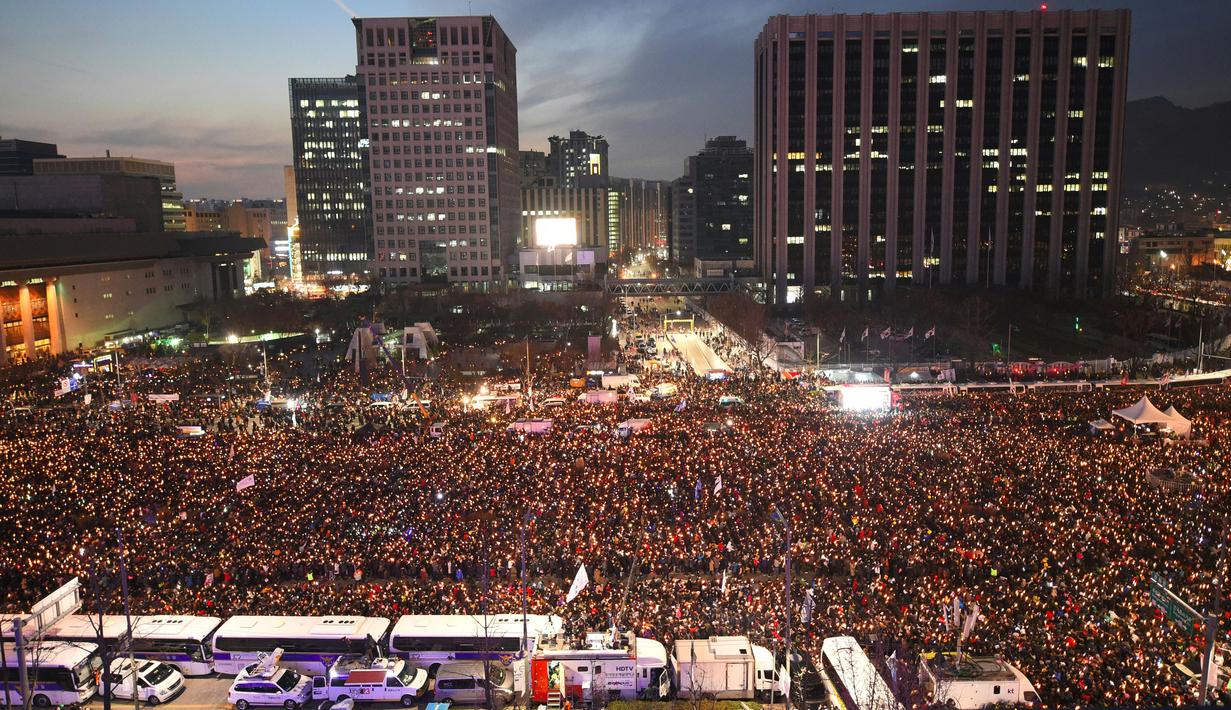Ratusan ribu pengunjuk rasa membawa lilin saat memadati jalan-jalan utama di pusat Kota Seoul, Korea Selatan, Sabtu (3/12). Presiden Park juga telah meminta parlemen memutuskan kapan dan bagaimana dirinya harus mundur dari jabatannya. (AFP/Jung Yeon-Je)