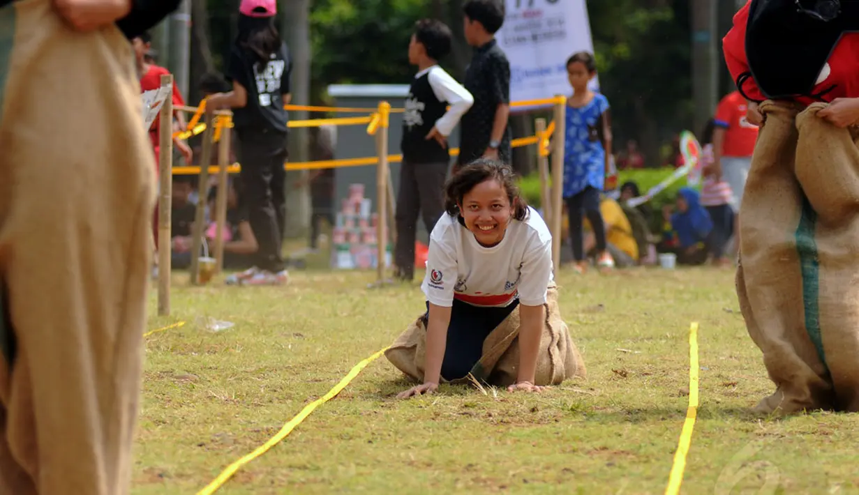 Salah satu peserta balap karung terjatuh saat berlomba dalam rangka memeriahkan HUT RI ke-69 di kawasan Tugu Monas, Jakarta, (31/8/2014). (Liputan6.com/Helmi Fithriansyah)