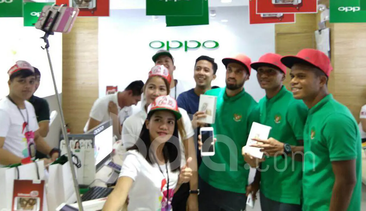 Stefano Lilipaly, M. Abduh Lestaluhu, dan Manahati Lestusen, berselfie dengan penjaga gerai telepon seluler di sebuah pusat perbelanjaan di Makati City, Manila, Filipina, Minggu (20/11/2016). (Bola.com/Nicklas Hanoatubun)