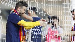 Bek Barcelona, Gerard Pique, melakukan selebrasi dengan menggunting jaring gawang usai menjuarai Copa del Rey di Stadion Olimpico de Sevilla, Minggu (18/4/2021). Barcelona menang 4-0 atas Athletic Bilbao. (AP Photo/Angel Fernandez)