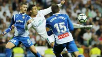 Bintang Real Madrid, Cristiano Ronaldo (tengah) melepaskan tembakan melewati adangan pemain Espanyol pada laga La Liga Santander di Santiago Bernabeu stadium, Madrid, (01/10/2017). Real Madrid menang 2-0. (AP/Paul White)
