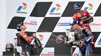 Pembalap Ducati Lenovo Team, Francesco Bagnaia (kanan atas), bersama pembalap Aprilia Racing, Maverick Vinales (kiri) dan pembalap Monster Energy Yamaha, Fabio Quartararo, melakukan selebrasi setelah menjadi juara di MotoGP Mandalika 2023, Minggu (15/10/2023) siang WIB. (AFP/Sonny Tumbelaka)