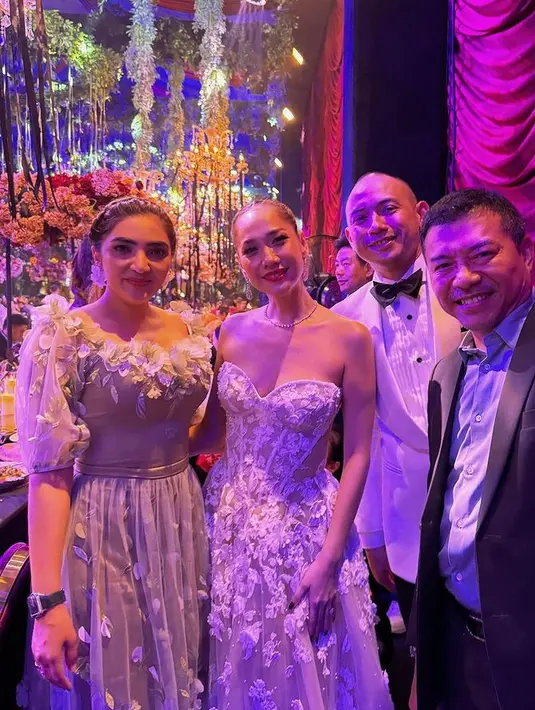 Saat hadir di resepsi pernikahan Bunga Citra Lestari di Bali, Ashanty hadir mengenakan dress lace lengan balon dengan bunga-bunga 3D. Busana tersebut pun dinilai netizen justru menyaingi pengantin perempuan. [@ashanty_ash]