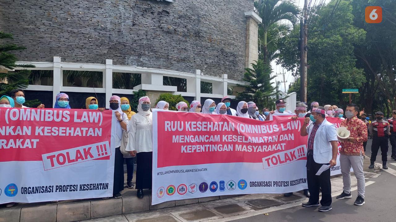 Puluhan dokter dan tenaga kesehatan yang tergabung dalam Ikatan Dokter Indonesia (IDI) Banyuwangi lakukan aksi unjuk rasa di depan Gedung DPRD Banyuwangi Tolak  RUU Omnibus Law Kesehatan (Hermawan Arifianto/Liputan6.com)