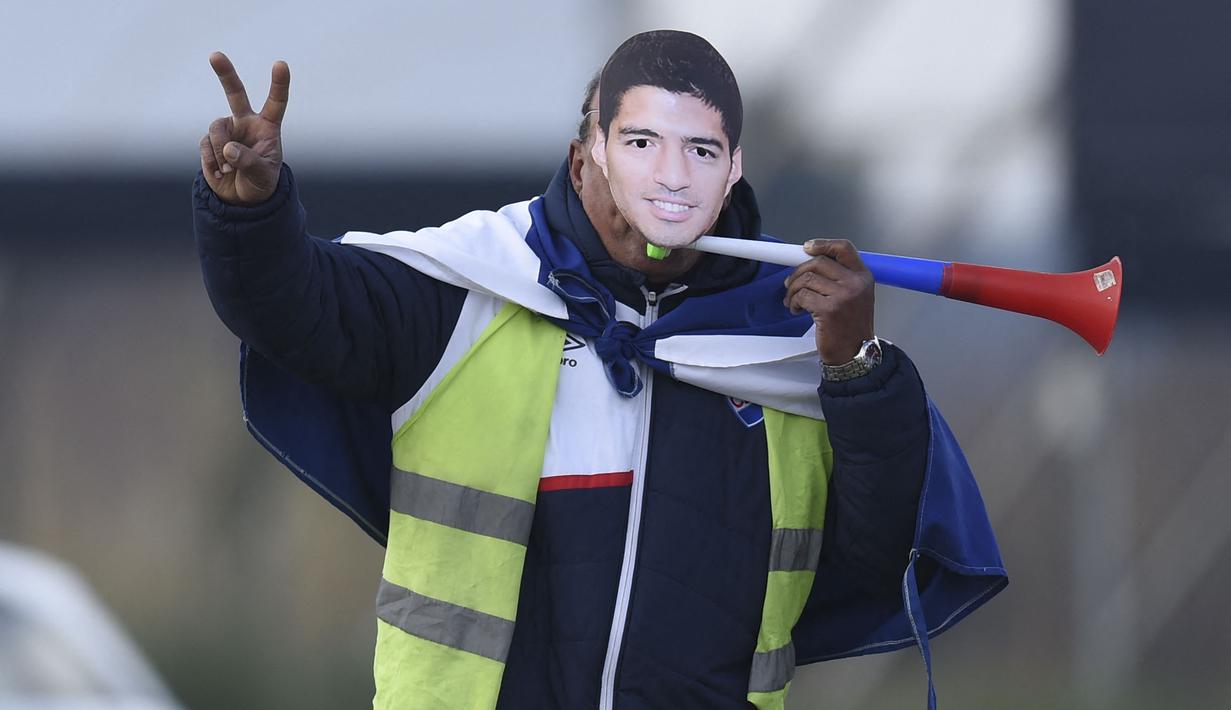 Seorang fans mengenakan topeng Luis Suarez saat sang pemain menghadiri upacara penyambutan sebagai pemain baru Nacional di Stadion Gran Parque Central, di Montevideo, pada 31 Juli, 2022. Luis Suarez kembali ke Uruguay untuk bergabung dengan Nacional, klub tempat ia memulai karirnya 17 tahun lalu sebagai salah satu striker terbaik di generasinya. (AFP/Pablo Porciuncula)