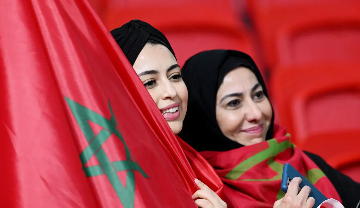 Fans Maroko tersenyum saat menyaksikan laga Maroko melawan Portugal pada laga Piala Dunia 2022 di Stadion Al-Thumama, Selasa (6/12/2022). (AFP/Kirill Kudryavtsev)