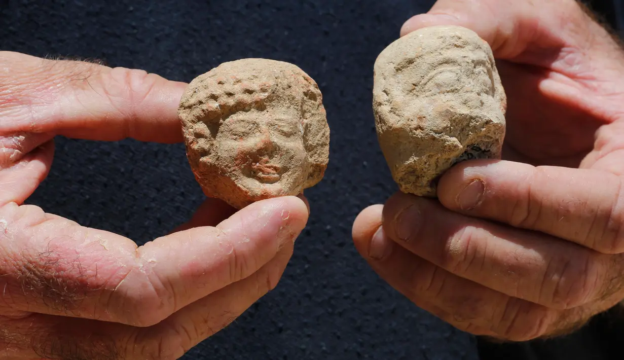 Seorang arkeolog menunjukkan pecahan keramik berupa stempel bertuliskan huruf Ibrani kuno yang ditemukan di sebuah situs penggalian di Yerusalem (22/7/2020). Tim arkeolog Israel menemukan pusat penyimpanan administratif berusia 2.700 tahun di Yerusalem. (Xinhua/Gil Cohen Magen)