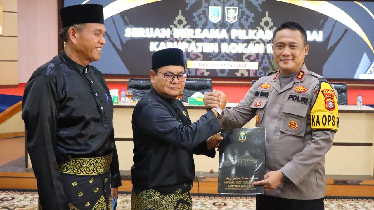 Kapolres Rokan Hilir bersama Ketua Lembaga Adat Melayu usai penandatanganan seruan Pilkada damai.