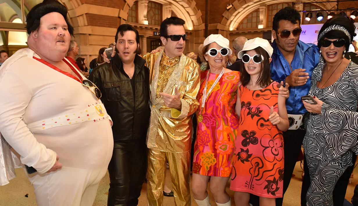 Sejumlah penggemar Elvis mengenakan kostum berfoto bersama sebelum naik kereta ke The Parkes Elvis Festival, di Sydney (11/1). The Parkes Elvis Festival adalah acara tahunan untuk mengenang kehidupan Elvis Presley di kota Parkes. (AFP Photo/Peter Parks)