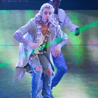 Terlihat sedikit labil, setelah meminta penggemarnya untuk tidak bising di konser, Justin Bieber pun kemudian membagikan bunga mawar untuk penggemarnya di halaman sebuah Club di London. (AFP/Bintang.com)
