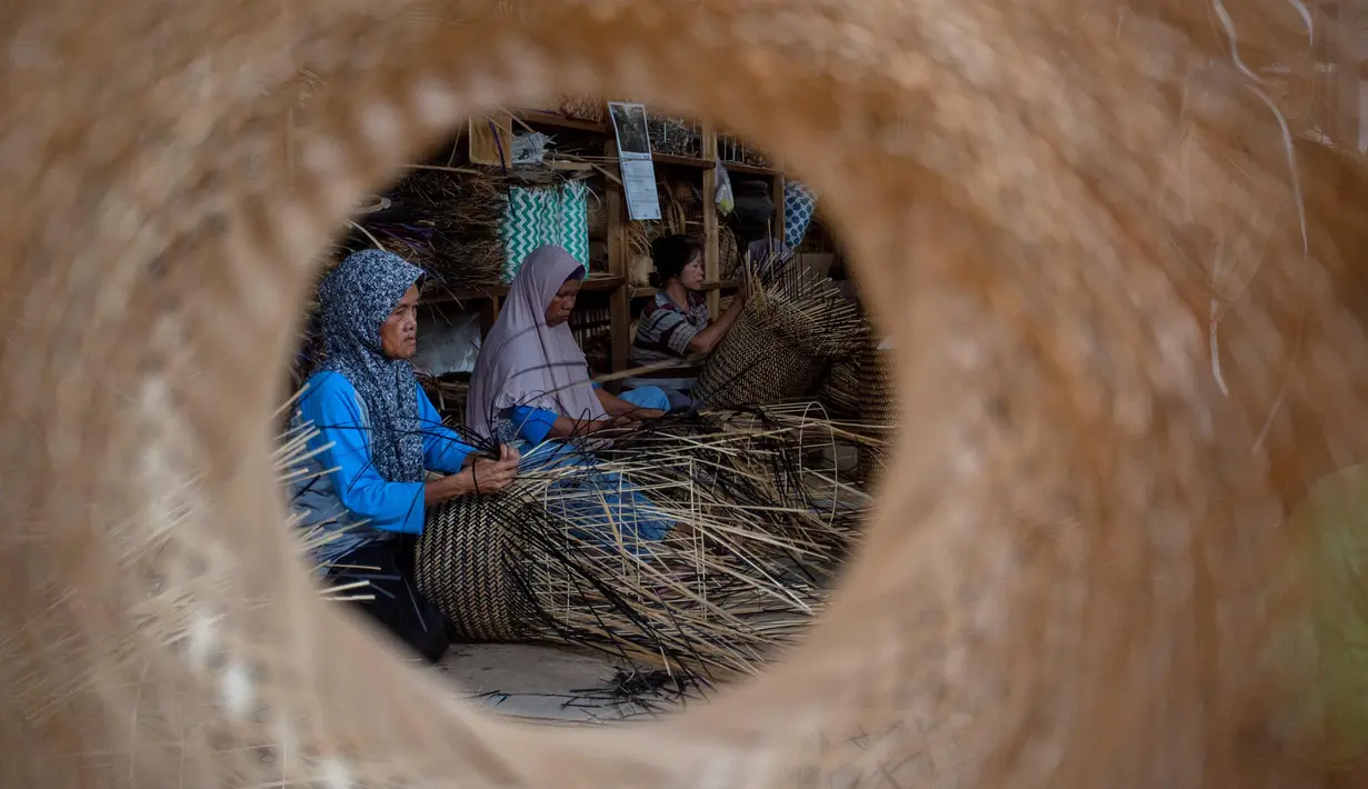 Para pekerja membuat keranjang dari bambu di tempat kerja mereka, Sleman, Yogyakarta pada 9 April 2025. (DEVI RAHMAN/AFP)