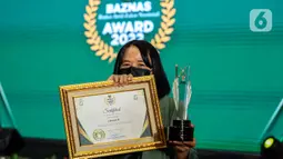 Pemimpin Redaksi Liputan6.com Irna Gustiawati berpose dengan penghargaan Baznas Award 2022 di The Sultan Hotel, Jakarta, Senin (17/1/2022). Media Liputan6.com menyabet penghargaan dari Badan Amil Zakat Nasional sebagai sebagai media pendukung gerakan zakat Indonesia. (Liputan6.com/Johan Tallo)