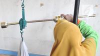 Petugas menimbang bayi saat pemeriksaan rutin kesehatan di Posyandu Ria Balita, Cipinang, Jakarta, Selasa (16/7/2019). Presiden Joko Widodo berencana memperkuat kebijakan sumber daya manusia (SDM). (merdeka.com/Iqbal Nugroho)
