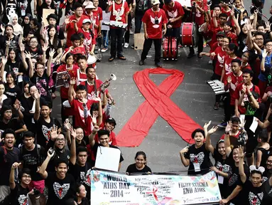 Massa membuat tanda pita sebagai simbol peduli terhadap pengidap HIV/AIDS, di Jalan MH Thamrin, Jakarta, MInggu (30/11/2014). (Liputan6.com/Faizal Fanani) 