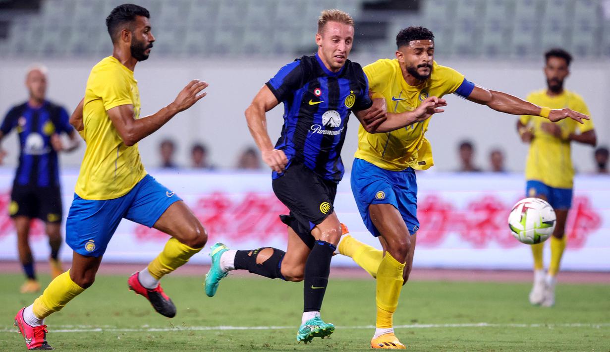 Dua pemain Al Nassr, Mohammed Al Fatil (kiri) dan Abdulelah Alamri berusaha mengadang laju gelandang Inter Milan, Davide Frattesi pada laga pramusim 2023/2024 di Nagai Stadium, Osaka, Jepang, Kamis (27/7/2023) sore WIB. (AFP/Paul Miller)