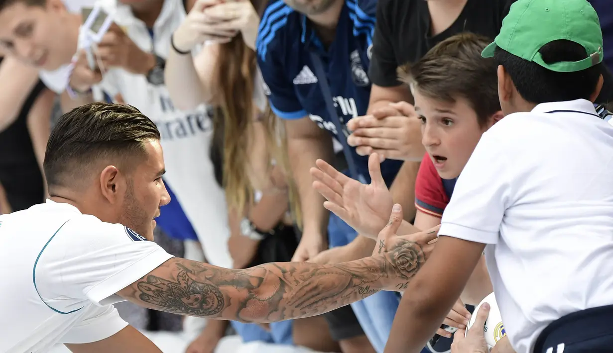 Pemain baru Real Madrid, Theo Hernandez, menyalami suporter saat baru diperkenalkan di Stadion Santiago Bernabeu, Madrid, Senin (10/7/2017). (AFP/Javier Soriano)