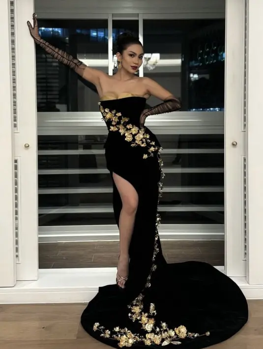 Sementara itu, Ariel Tatum mengenakan dress hitam strapless dengan bagian dada dihiasi kain warna gold. Gaun flowy slit ini dibuat oleh desainer Didiet Maulana. Gaun semakin tampak mewah dengan aksen bunga 3d warna gold. [@arieltatum]