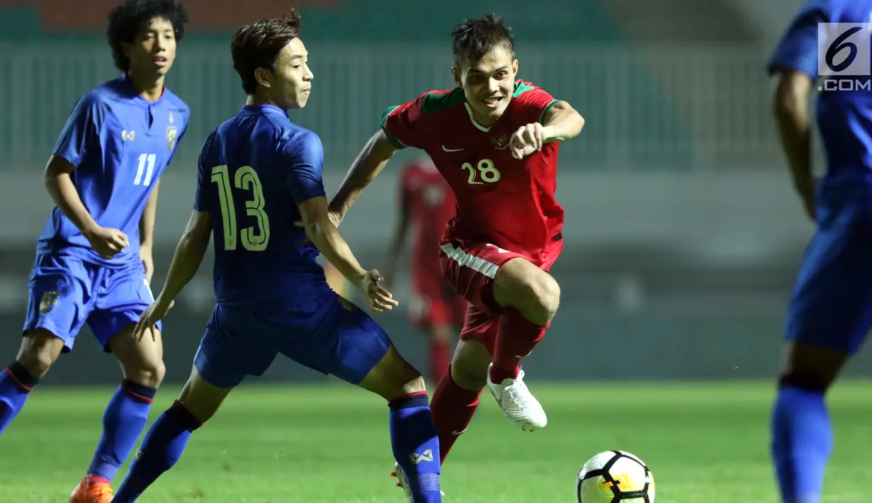 Bek Timnas Indonesia U-23, M Rezaldi Hehanusa (tengah) mencoba melewati adangan pemain Thailand U-23 pada laga persahabatan di Stadion Pakansari, Kab Bogor, Minggu (3/6). Laga berakhir imbang 0-0. (Liputan6.com/Helmi Fithriansyah)