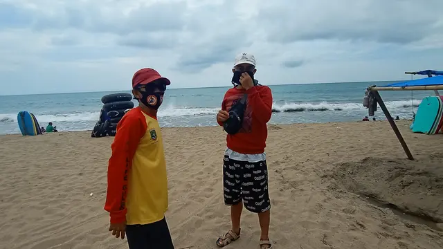 Personil Balawista Kabupaten Serang Mengingatkan Wisatawan Memakai Masker Di Pantai Panjang, Bandulu, Anyer. (Sabtu, 31/10/2020). (Yandhi Deslatama/Liputan6.com)
