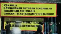 Spanduk berisikan tuntutan ahli waris yang dipasang di pintu gerbang SDN Bantargebang IV, Kota Bekasi. (Liputan6.com/Bam Sinulingga)