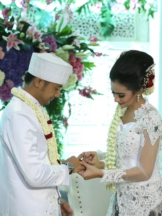 Sonya Fatmala memasangkan cincin ke suami tercintanya, Hengky Kurniawan. (Galih W. Satria/bintang.com)