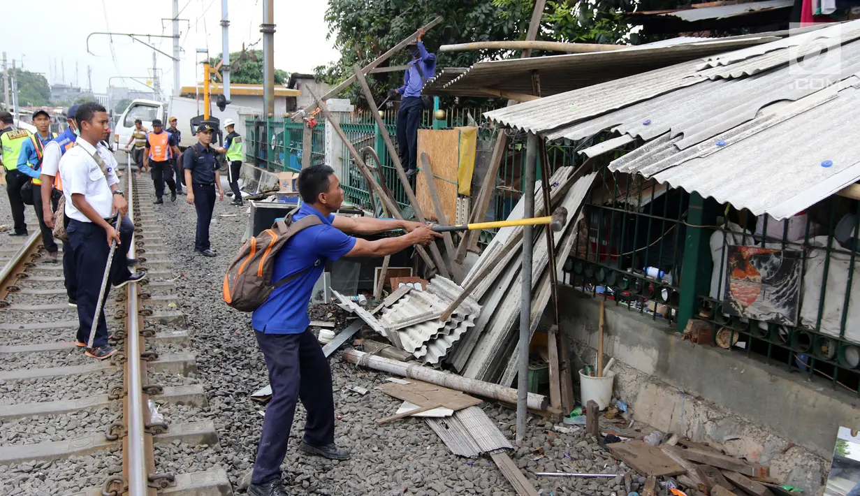 Petugas gabungan melakukan penertiban di sepanjang jalur kereta di kawasan Grogol, Jakarta Barat, Kamis (22/2). Penertiban tersebut untuk mensterilkan jalur kereta dari lapak atau bangunan liar yang berdiri di dalam pagar. (Liputan6.com/Arya Manggala)